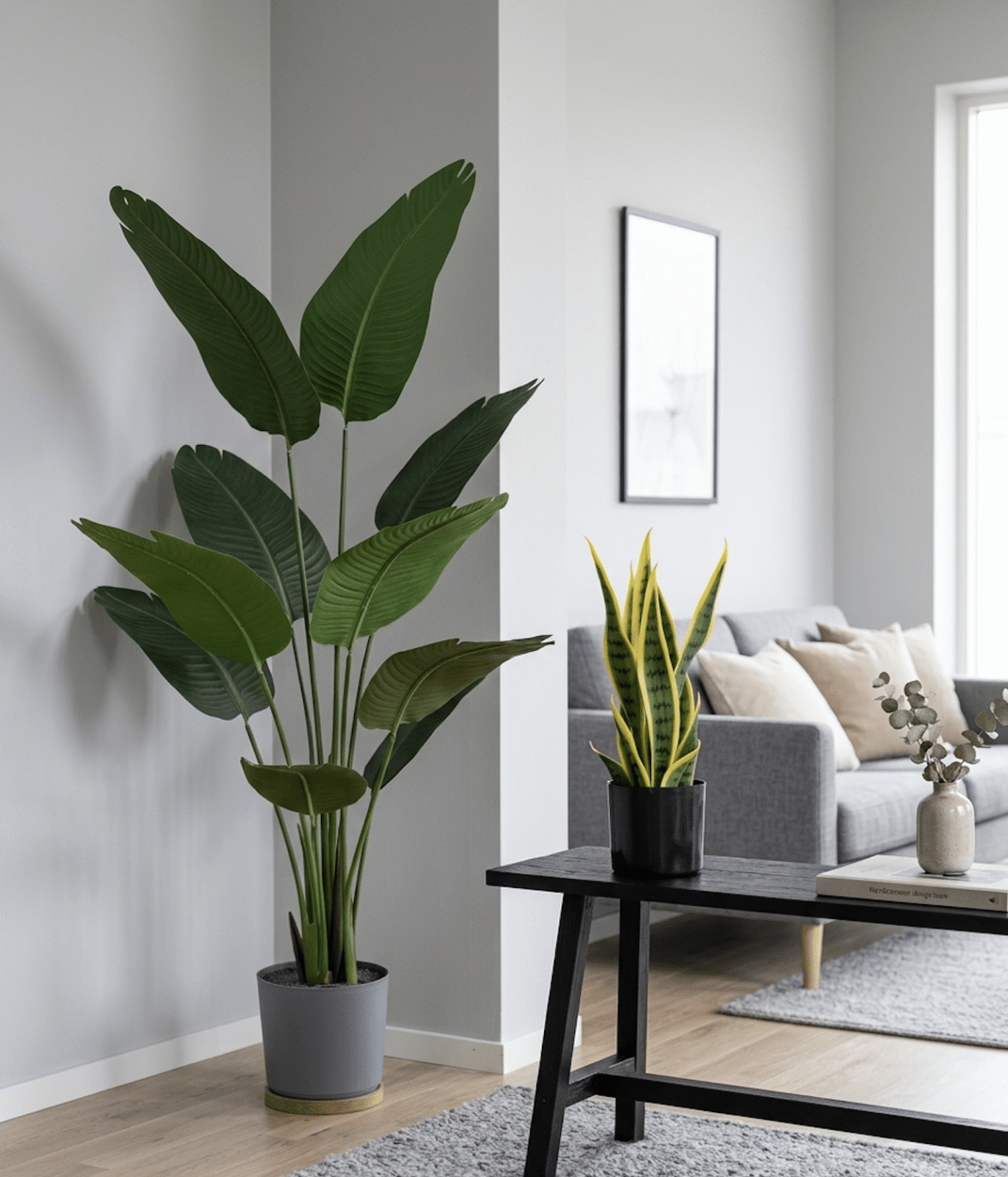 Ett ljust vardagsrum med naturtrogna konstgjorda växter som Strelitzia och svärmorstunga.